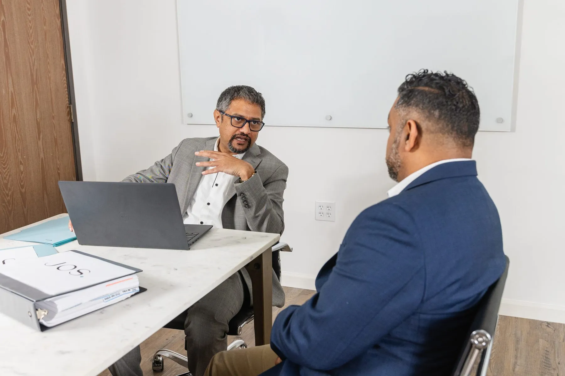 Binoye Jos and Shakeb A. Razai discussing a matter at the Jos Family Law office